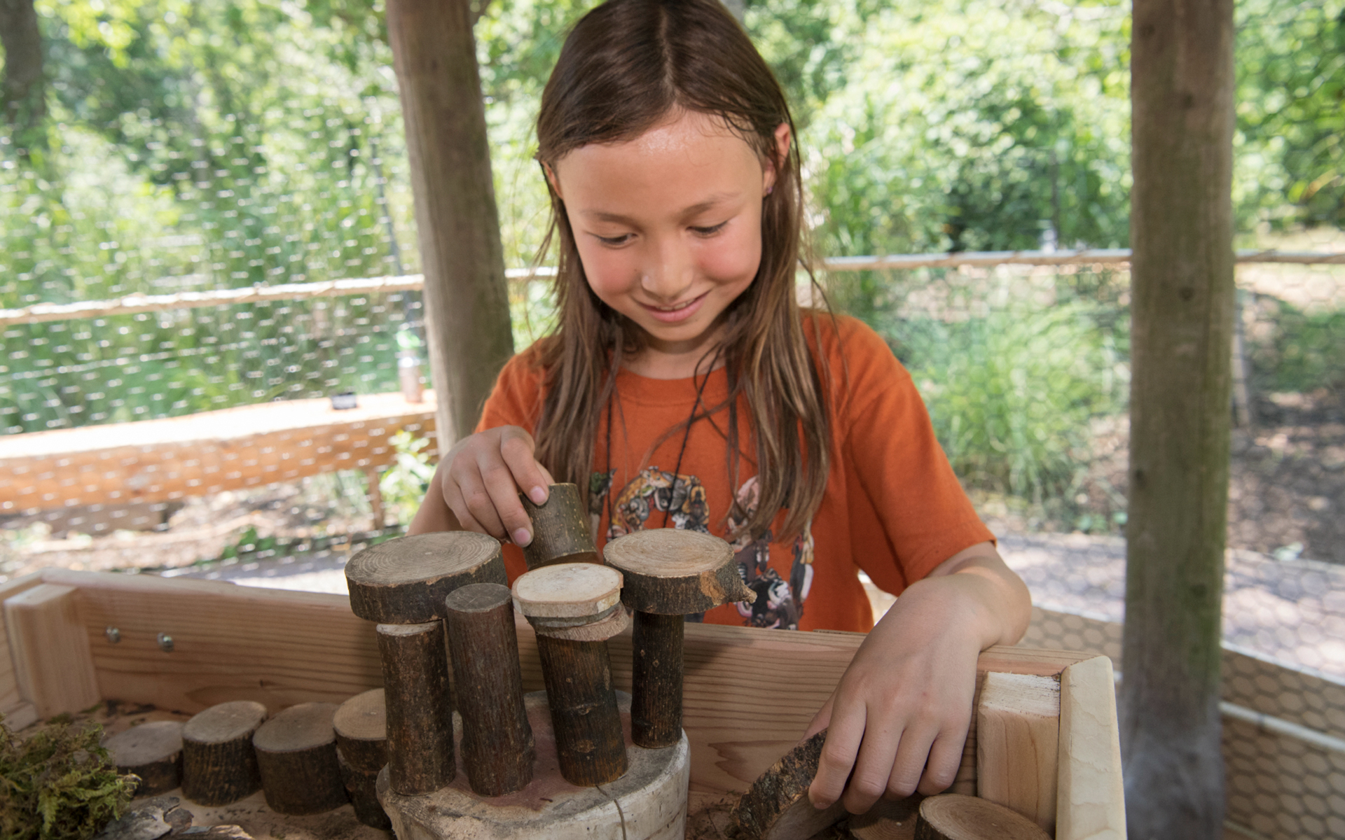 girl stacking pieces of wood at the nature trek