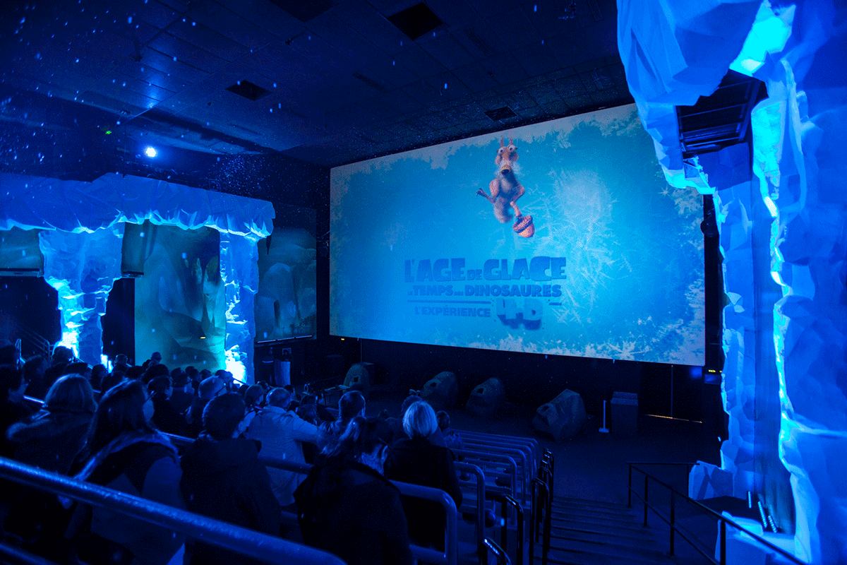 blue lit theater interior with ice age on screen